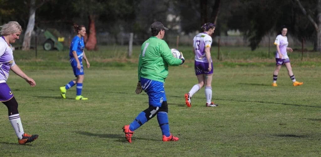 Linda is an avid soccer player, and here she is in a game photo. Linda is a goal keeper and she's playing the ball, with the ball in her hands.