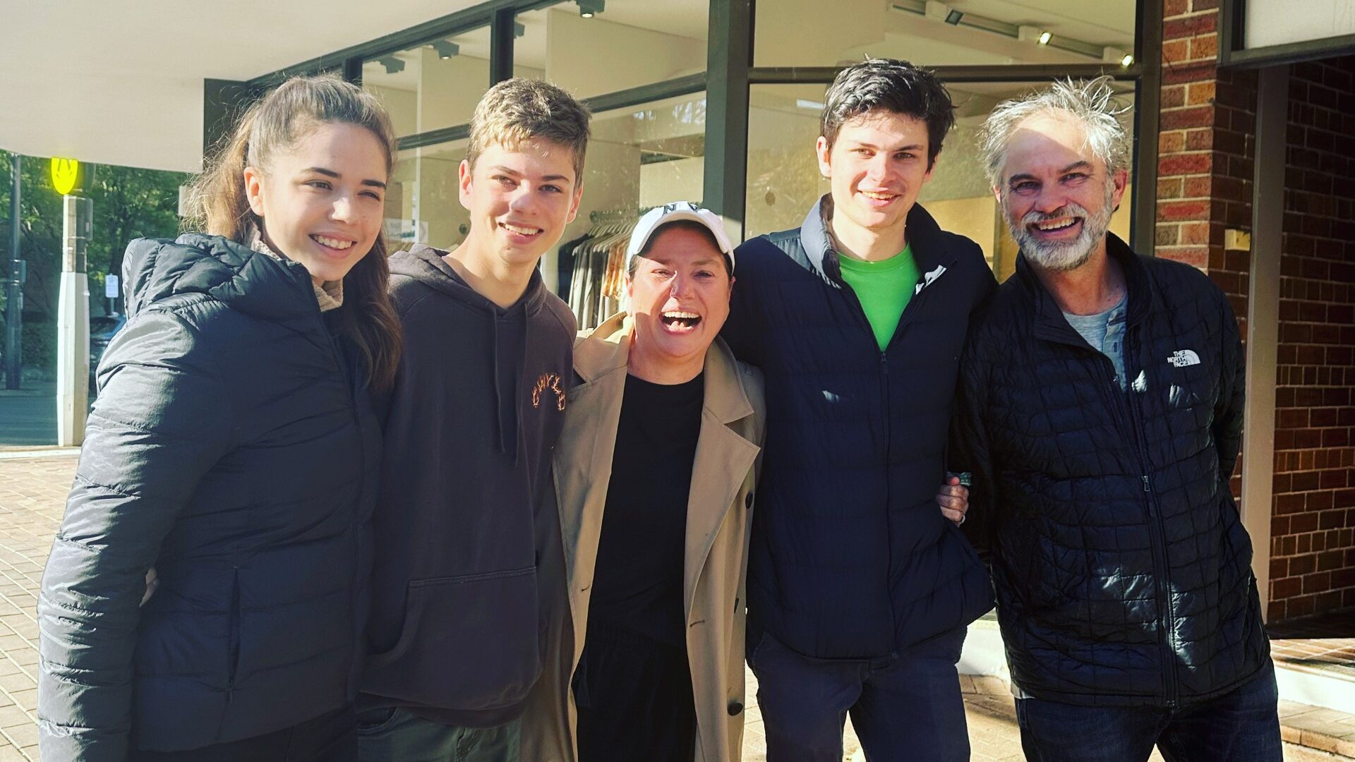 Margie outside with her family. They're smiling ear to ear with happiness.